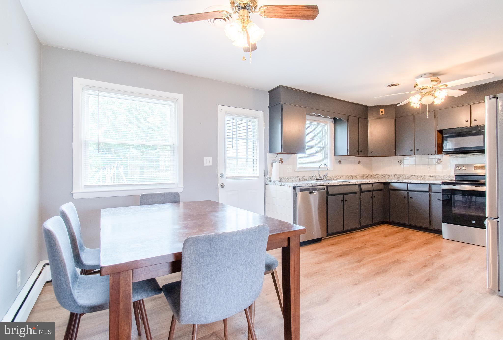 3911 Sunset Drive Hampstead, MD 21074 - Photo 15 of 38 a kitchen with a table chairs sink and cabinets