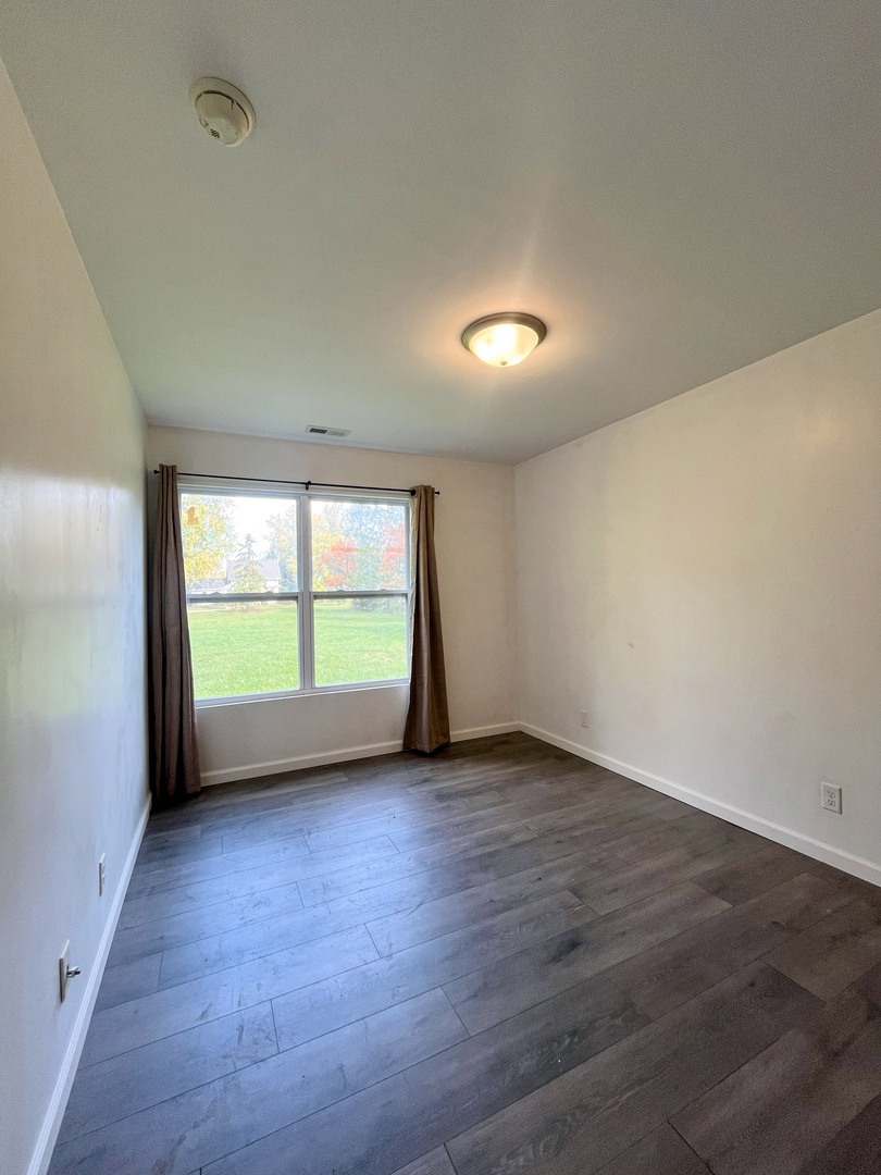 340 North Wooster Street Capron, IL 61012 - Photo 13 of 32 an empty room with wooden floor and windows