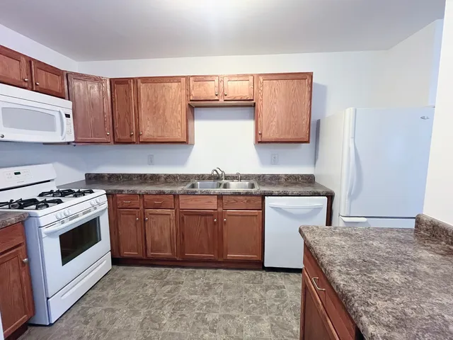 a kitchen with stainless steel appliances granite countertop a stove a sink and a microwave