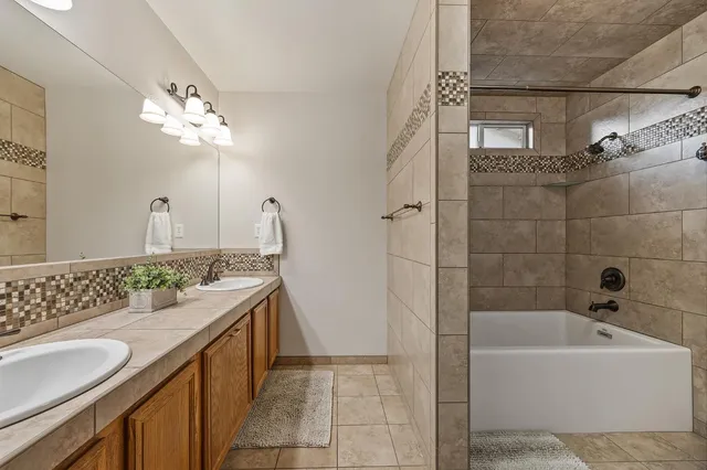 a backyard of a house with table and chairs under an umbrella