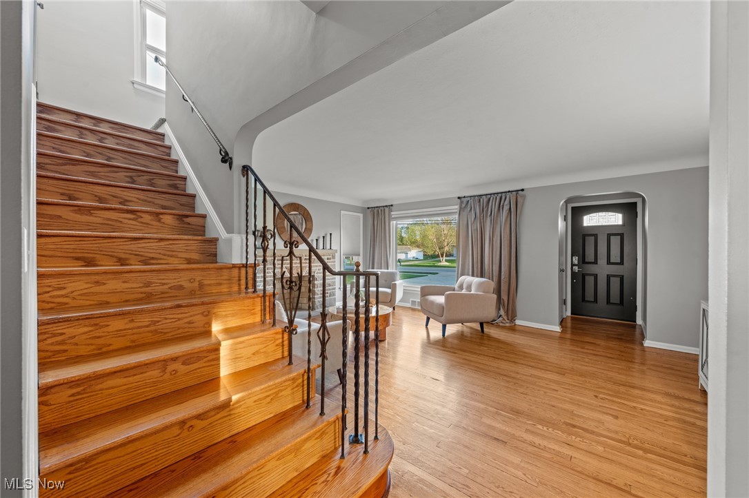 6315 Brookside Road Independence, OH 44131 - Photo 22 of 41 Foyer with light wood-style floors, arched walkways, baseboards, and stairway