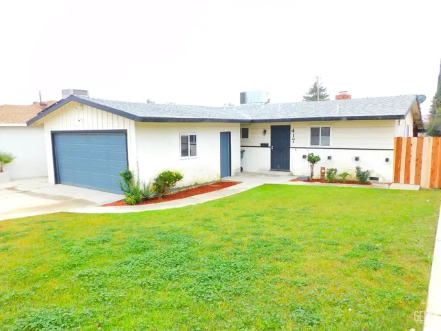a view of a house with a yard and garage