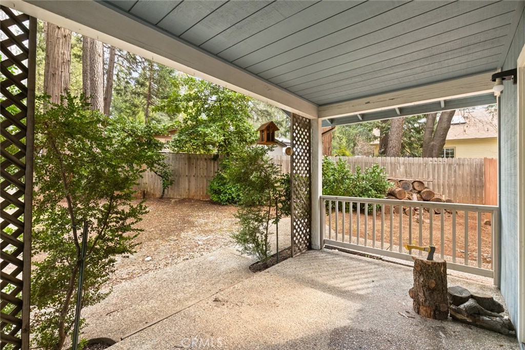 14366 Carnegie Road Magalia, CA 95954 - Photo 21 of 28 a porch with a table and chairs in front of it with wooden fence