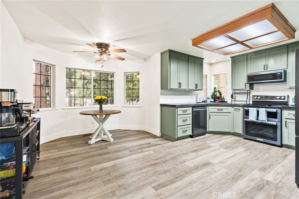 14366 Carnegie Road Magalia, CA 95954 - Photo 7 of 28 a kitchen with kitchen island a stove a sink a refrigerator dining table and chairs with wooden floor