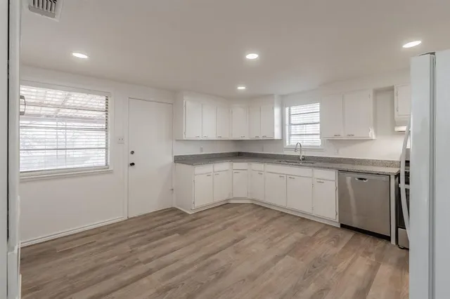 a kitchen with granite countertop white cabinets and white appliances