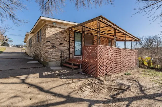 a view of a house with a large tree and a yard