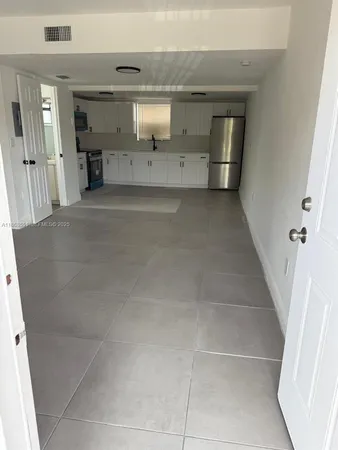 a view of a refrigerator in kitchen and entryway