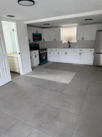 a kitchen with stainless steel appliances a stove refrigerator and cabinets