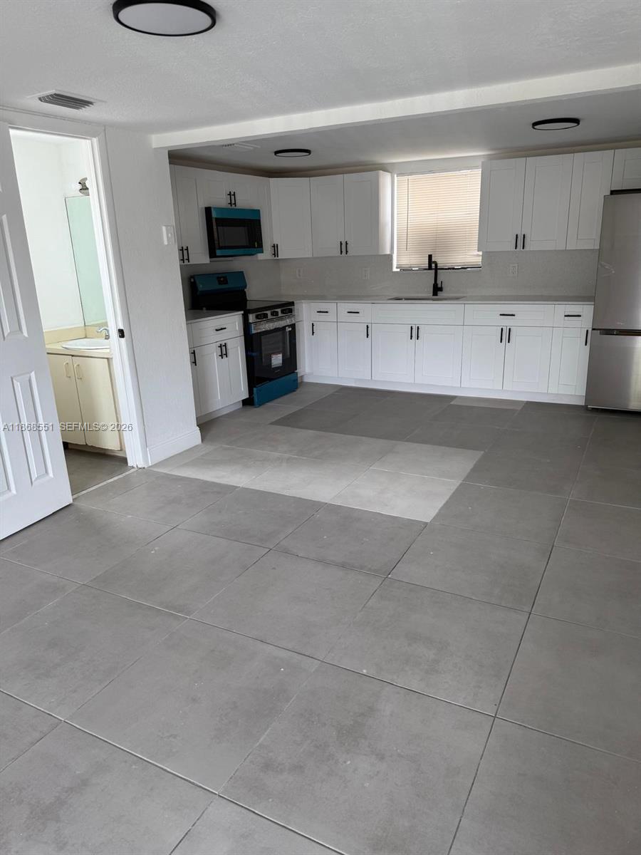 2291 West 53rd Place, Unit 2291 Hialeah, FL 33016 - Photo 5 of 11 a kitchen with stainless steel appliances a stove refrigerator and cabinets