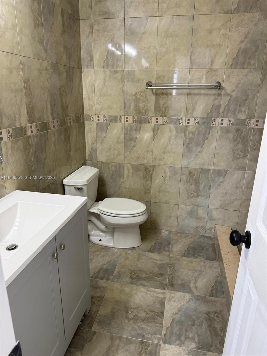 2291 West 53rd Place, Unit 2291 Hialeah, FL 33016 - Photo 9 of 11 a bathroom with a sink a toilet and shower