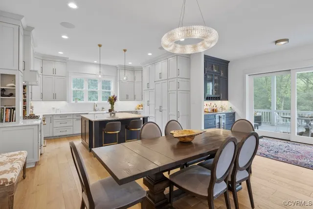 a kitchen with stainless steel appliances granite countertop a table chairs sink refrigerator and microwave