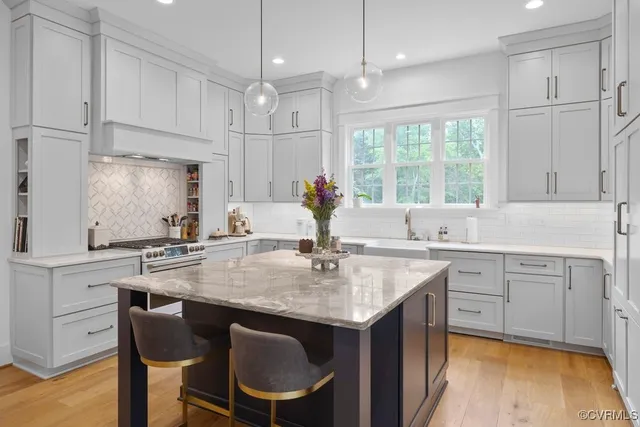 a kitchen with kitchen island granite countertop a sink cabinets and wooden floor