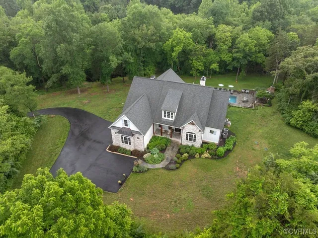 an aerial view of a house with a yard basket ball court and outdoor seating