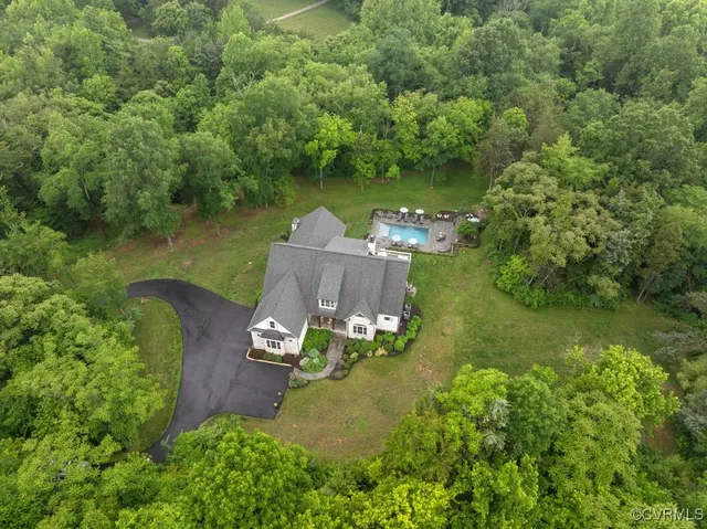 an aerial view of a house with a yard basket ball court and outdoor seating