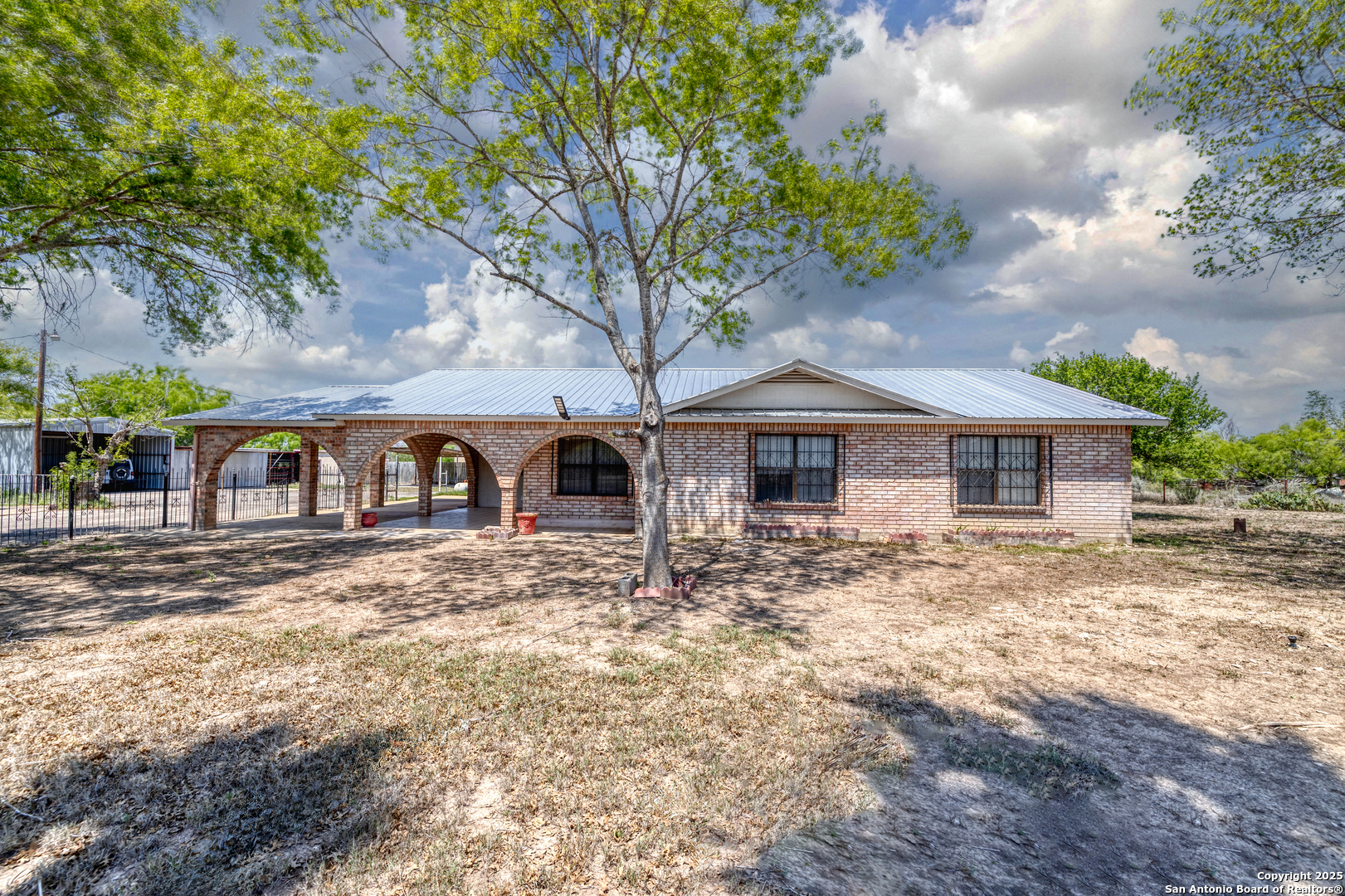 a front view of house with yard and trees around
