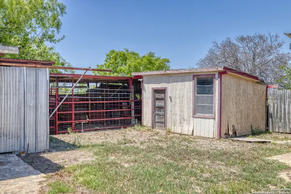 a view of a backyard with a small barn and wooden fence