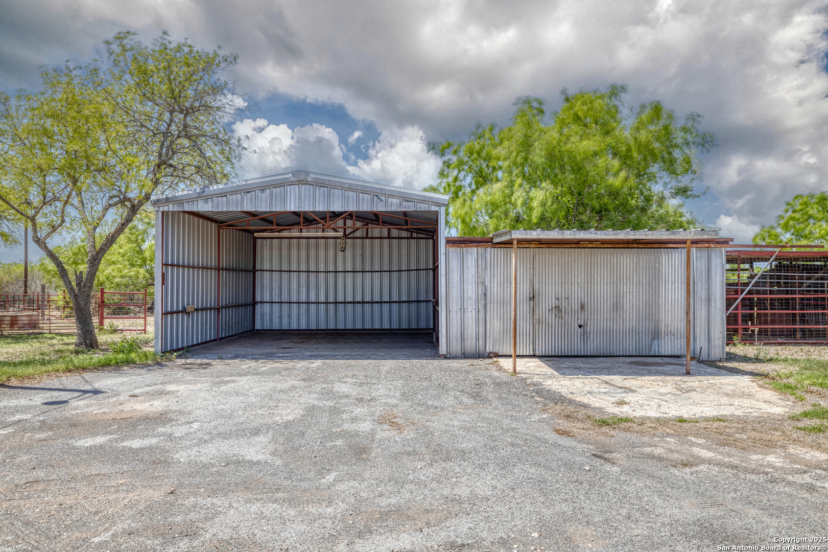 1390 Windmill Road Uvalde, TX 78801 - Photo 24 of 44 a view of a backyard with a small barn and wooden fence