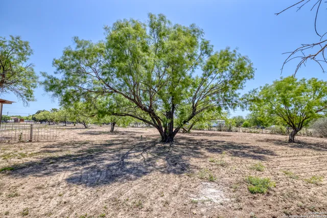 a view of backyard with table and chairs and wooden fence
