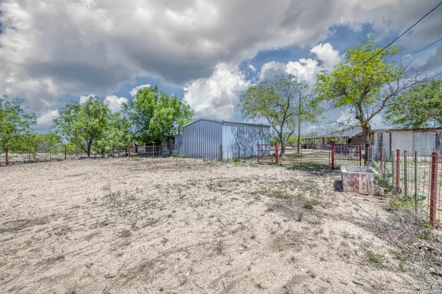 a view of a house with a yard and wooden fence
