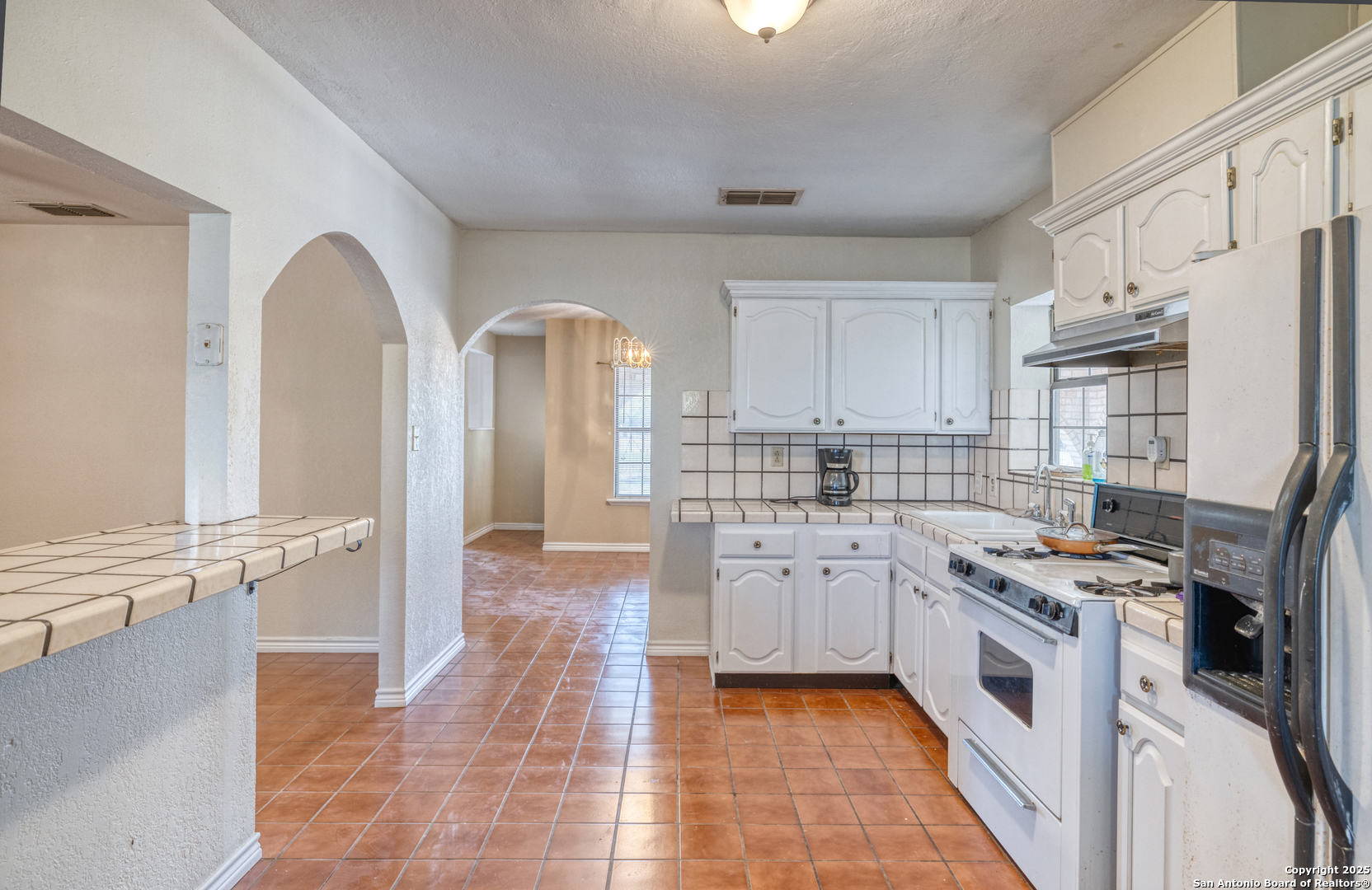 1390 Windmill Road Uvalde, TX 78801 - Photo 8 of 44 a kitchen with stainless steel appliances granite countertop a stove a sink and a refrigerator