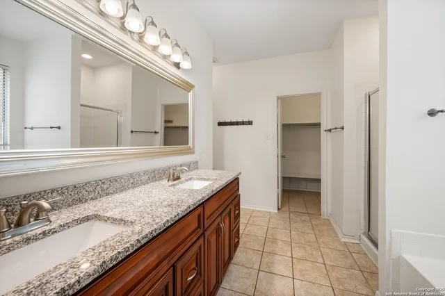 a bathroom with a granite countertop sink a mirror and a bathtub