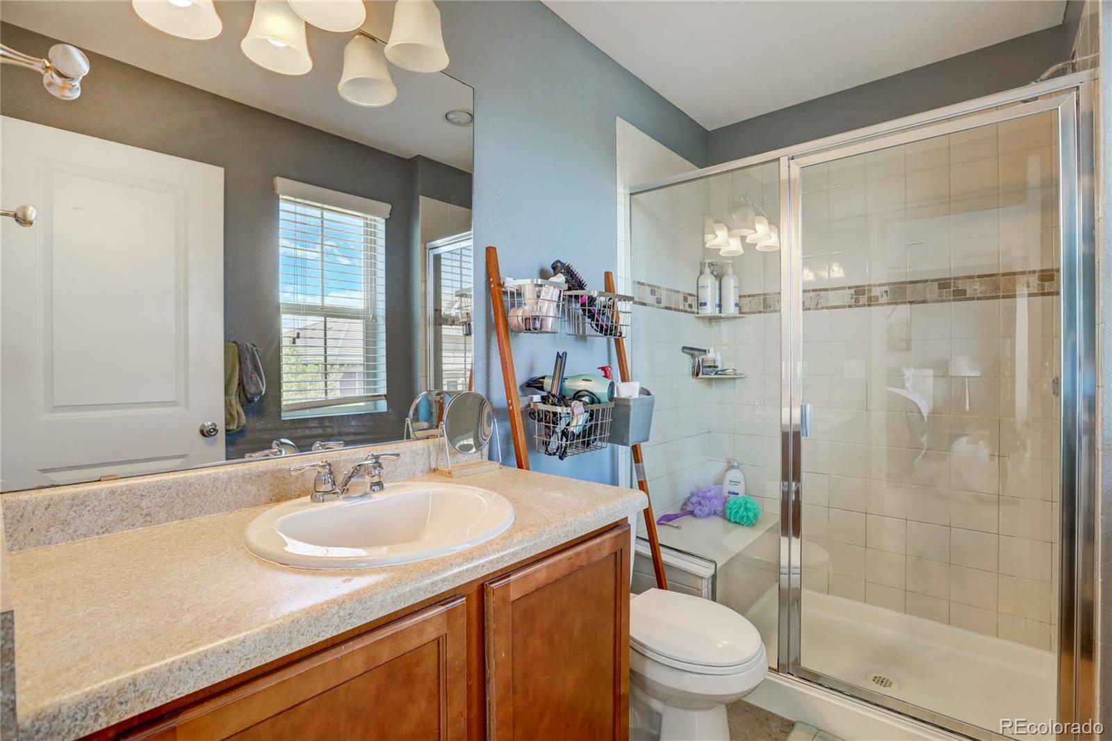 10321 Bellwether Lane Lone Tree, CO 80124 - Photo 19 of 32 a bathroom with a sink toilet vanity and shower