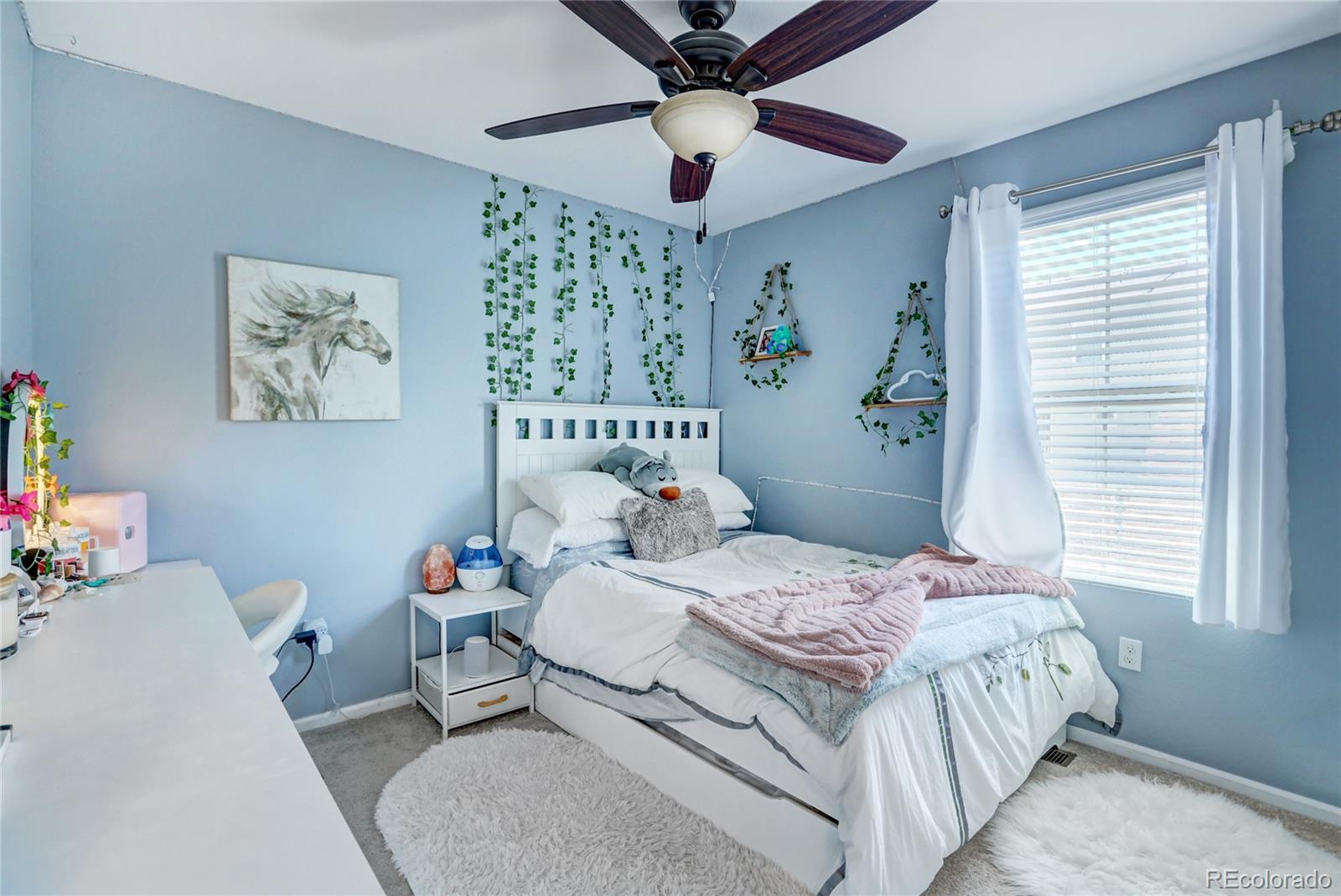 10321 Bellwether Lane Lone Tree, CO 80124 - Photo 20 of 32 a bedroom with a bed and a chandelier
