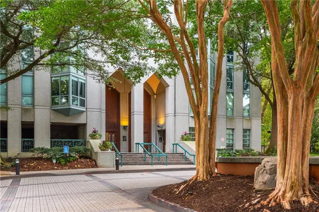 a view of a multi story residential apartment building with a yard