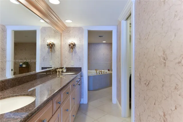 a spacious bathroom with a granite countertop sink a mirror and a bathtub