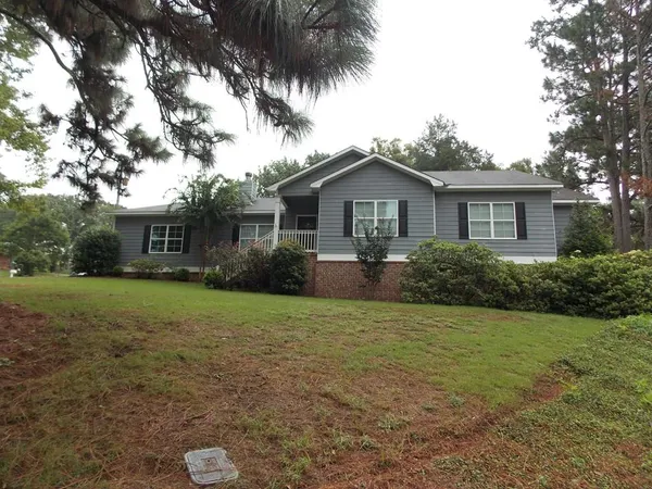 a front view of a house with a yard and trees