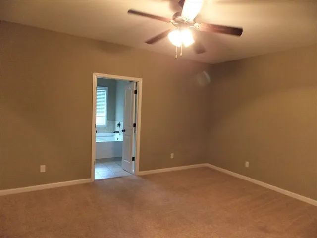 an empty room with a ceiling fan and a window