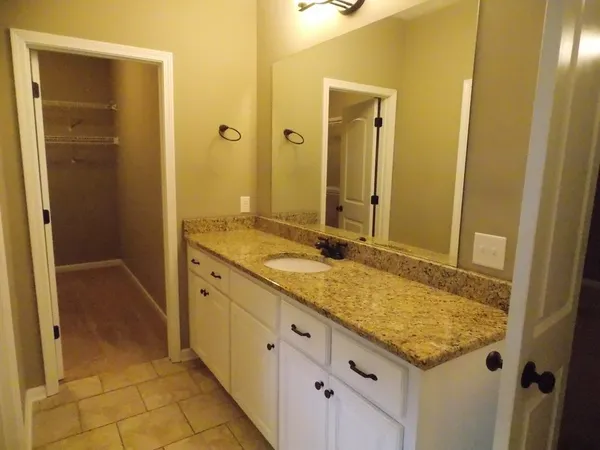 a bathroom with a granite countertop sink and a mirror