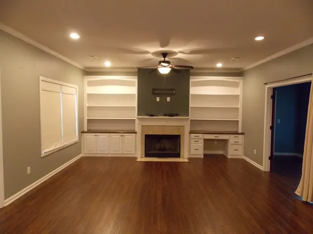 a view of a room with a flat screen tv wooden floor and a kitchen