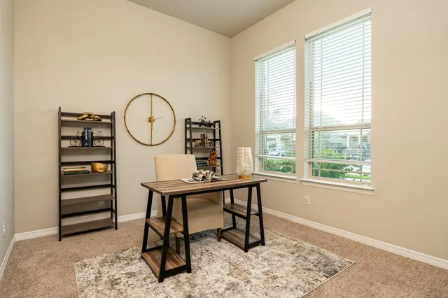 a view of a workspace with furniture and a window