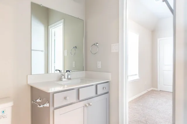 a bathroom with a sink vanity and mirror