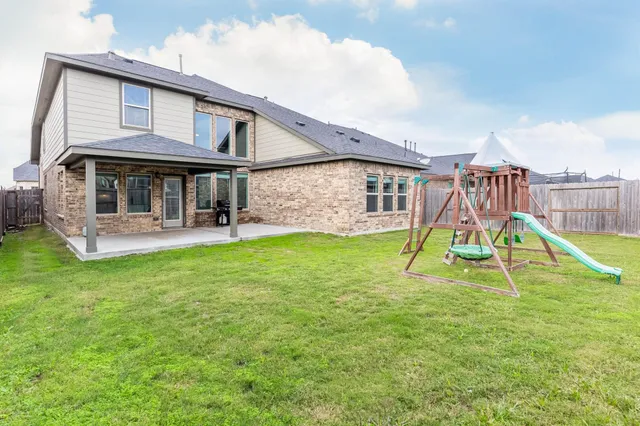 a house view with a garden space and slide