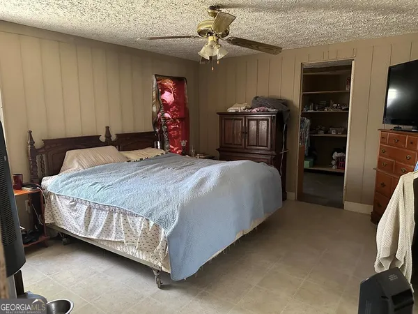a spacious bedroom with a bed and a chandelier