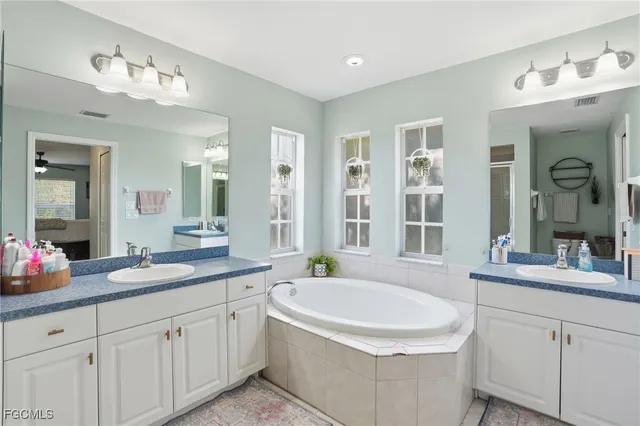 a spacious bathroom with a double vanity sink mirror and shower