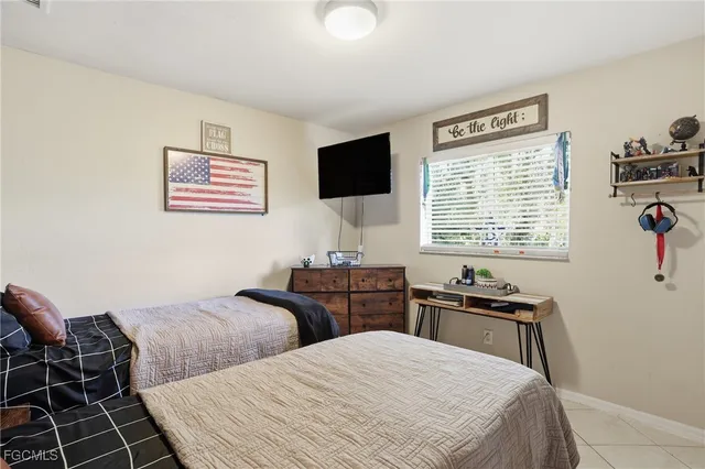 a bedroom with two bed and a lamp on dresser