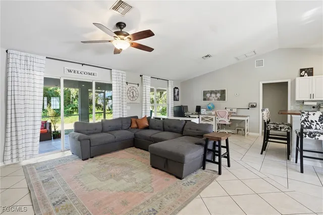 a living room with furniture and a large window with wooden floor