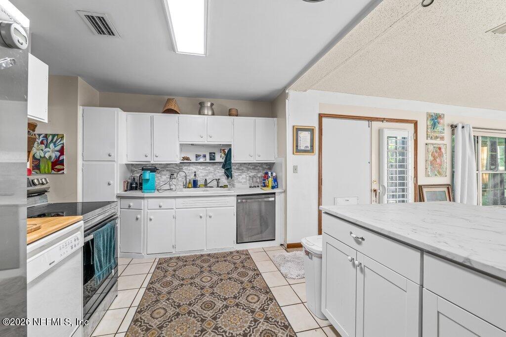 1226 Halifax Road Jacksonville, FL 32216 - Photo 12 of 29 a kitchen with granite countertop white cabinets and white appliances