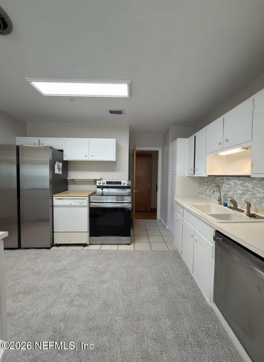 1226 Halifax Road Jacksonville, FL 32216 - Photo 7 of 29 a kitchen with stainless steel appliances a refrigerator sink and cabinets