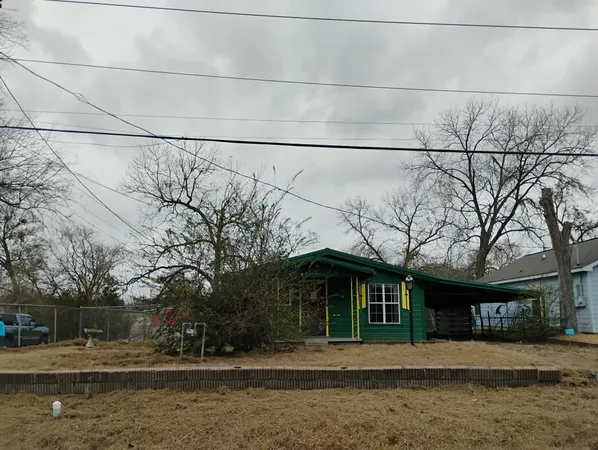 a front view of a house with large trees