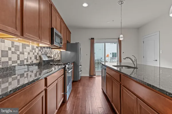a kitchen with stainless steel appliances granite countertop a sink stove and cabinets