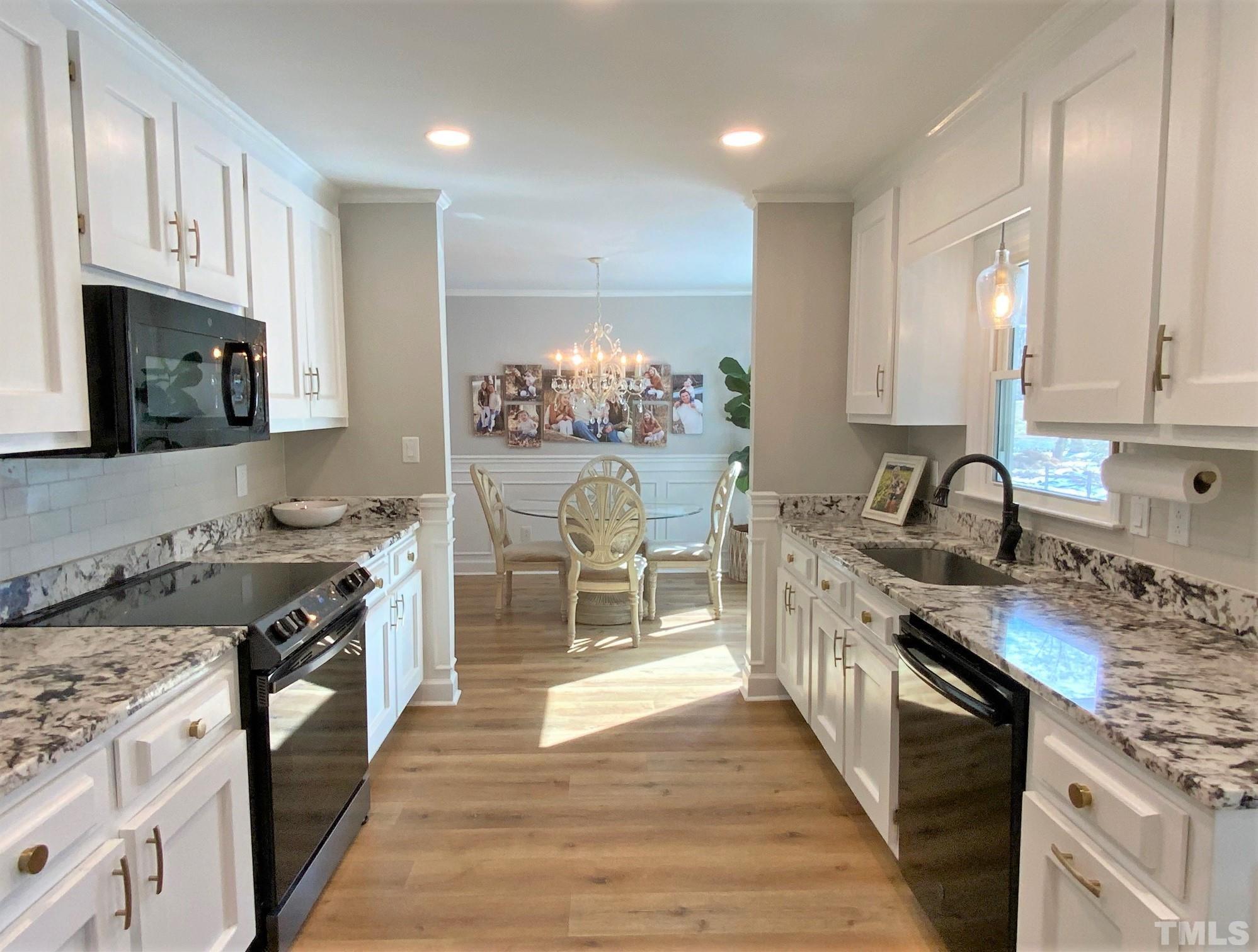 5514 Guess Road Rougemont, NC 27572 - Photo 10 of 21 a kitchen with stainless steel appliances granite countertop a stove top oven a sink dishwasher and a refrigerator with wooden floor