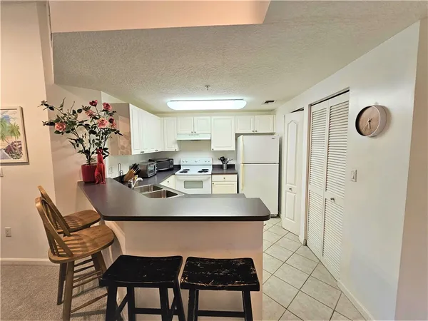 a view of kitchen island with furniture and refrigerator