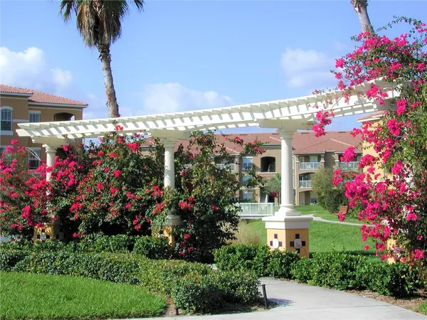 a front view of a multi story building with a lot of flower plants