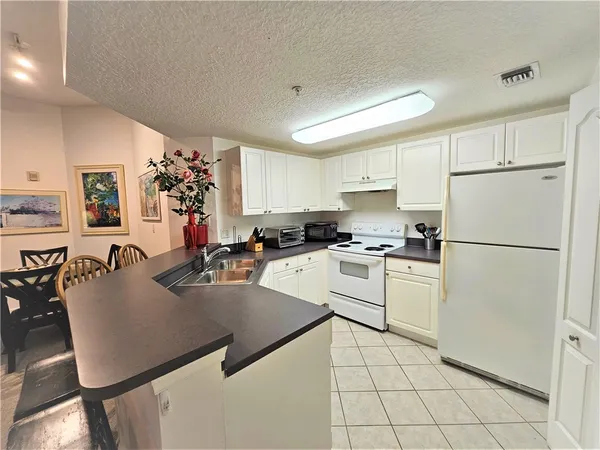 a kitchen with a sink a refrigerator and cabinets