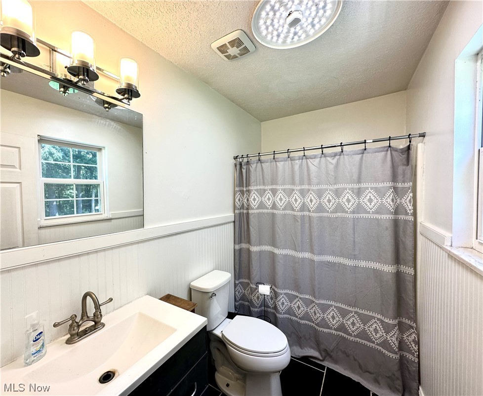 444 Eyermann Road Belpre, OH 45714 - Photo 12 of 16 Bathroom featuring toilet, tile flooring, a textured ceiling, and vanity