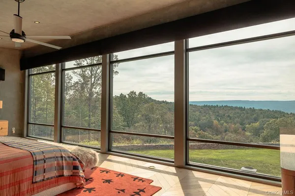 a bedroom with bed and large windows